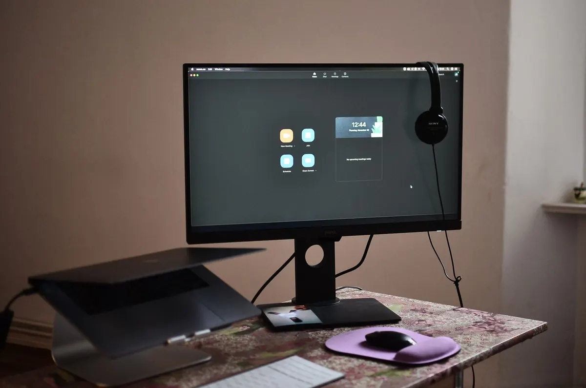 Assistenza software a Latina: postazione con monitor acceso sulla schermata di accesso al sistema, cuffie con microfono e scrivania di lavoro