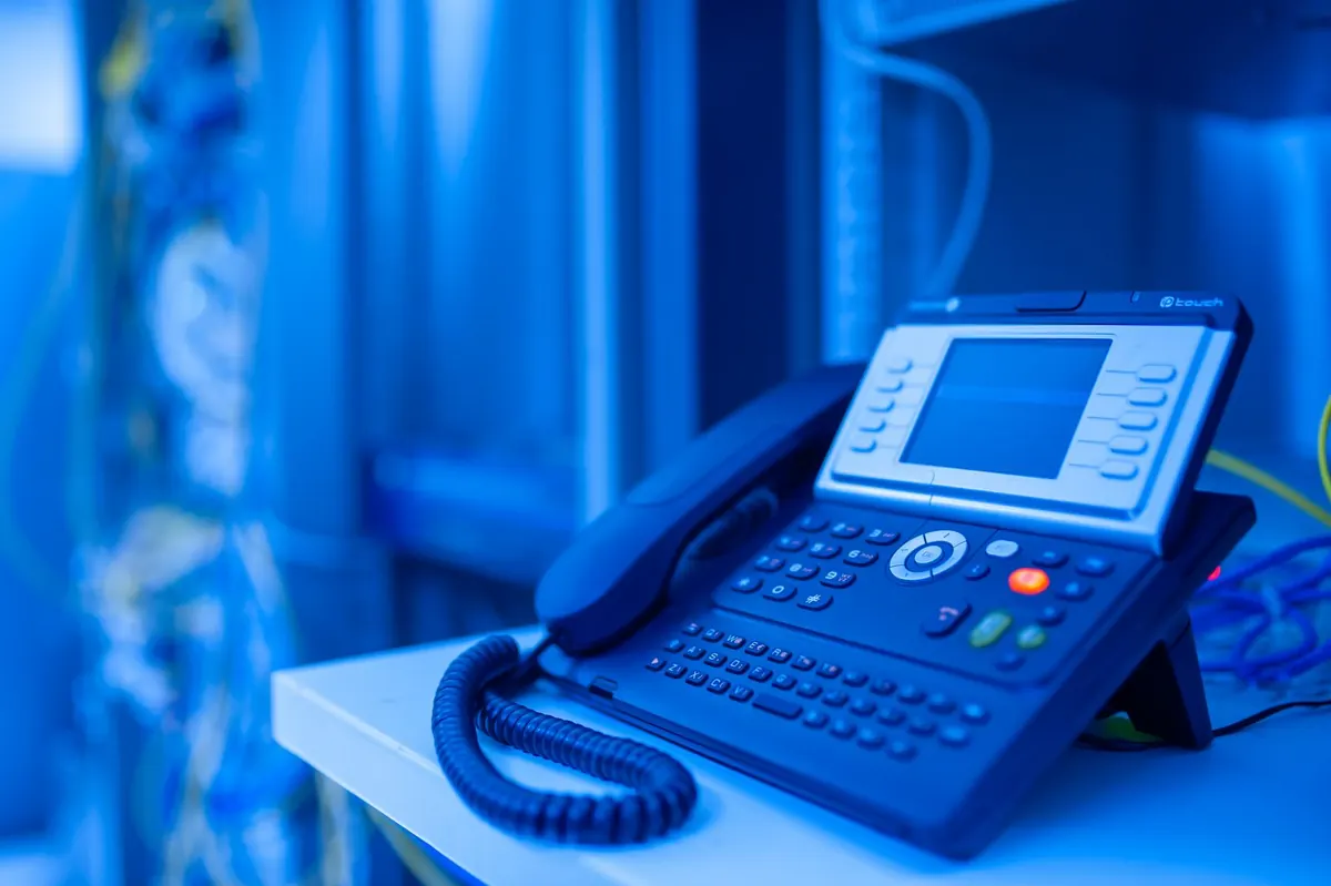 Centralino VoIP PBX a Latina: telefono IP da scrivania con display a colori e cornetta in un ufficio aziendale