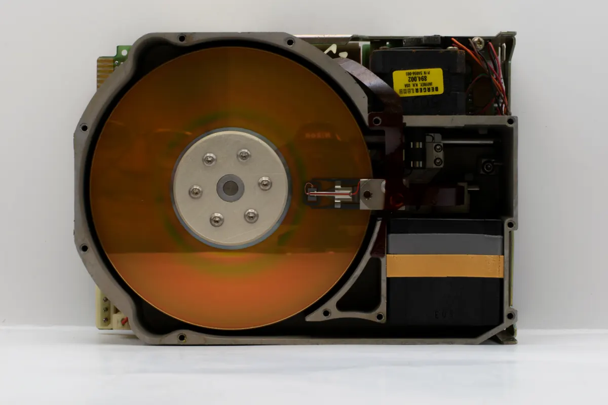 Riparazione hardware con recupero dati: disco fisso aperto con il piatto e la testina di lettura in vista