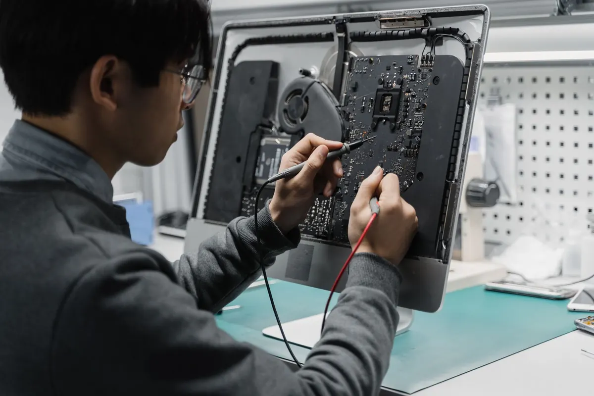 Riparazione hardware a Latina: tecnico al banco di laboratorio mentre interviene con attrezzi di precisione sull'interno aperto di un computer