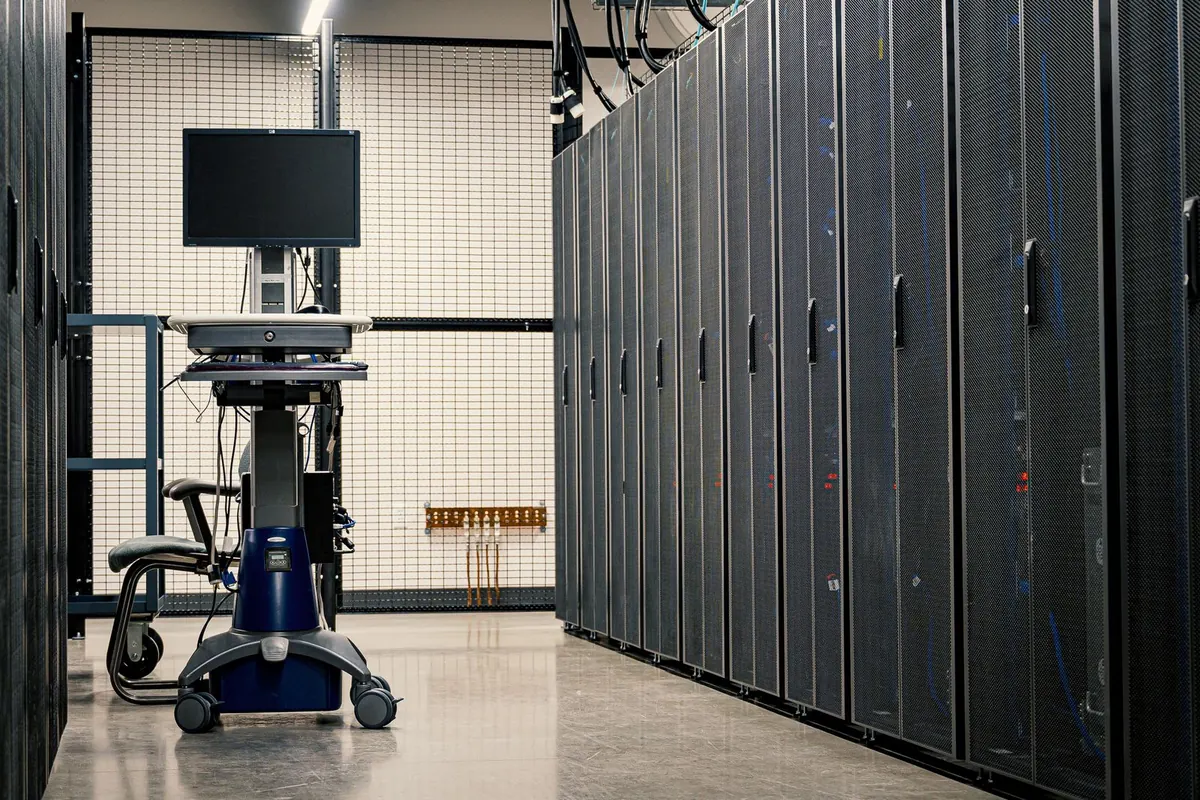 Sala server a Latina: armadi rack allineati con apparati di rete e cavi in fibra ottica collegati