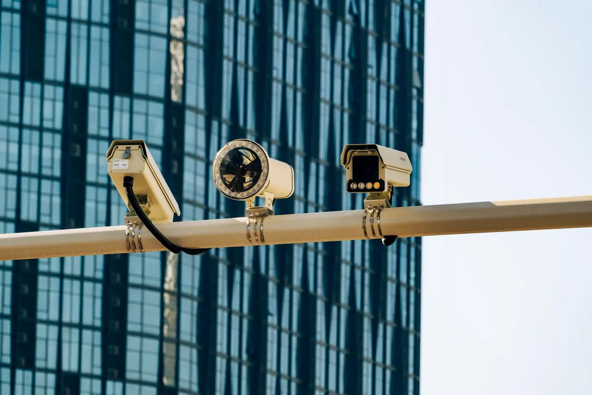 Impianto di videosorveglianza a Latina: due telecamere su palo davanti a un edificio con facciata vetrata