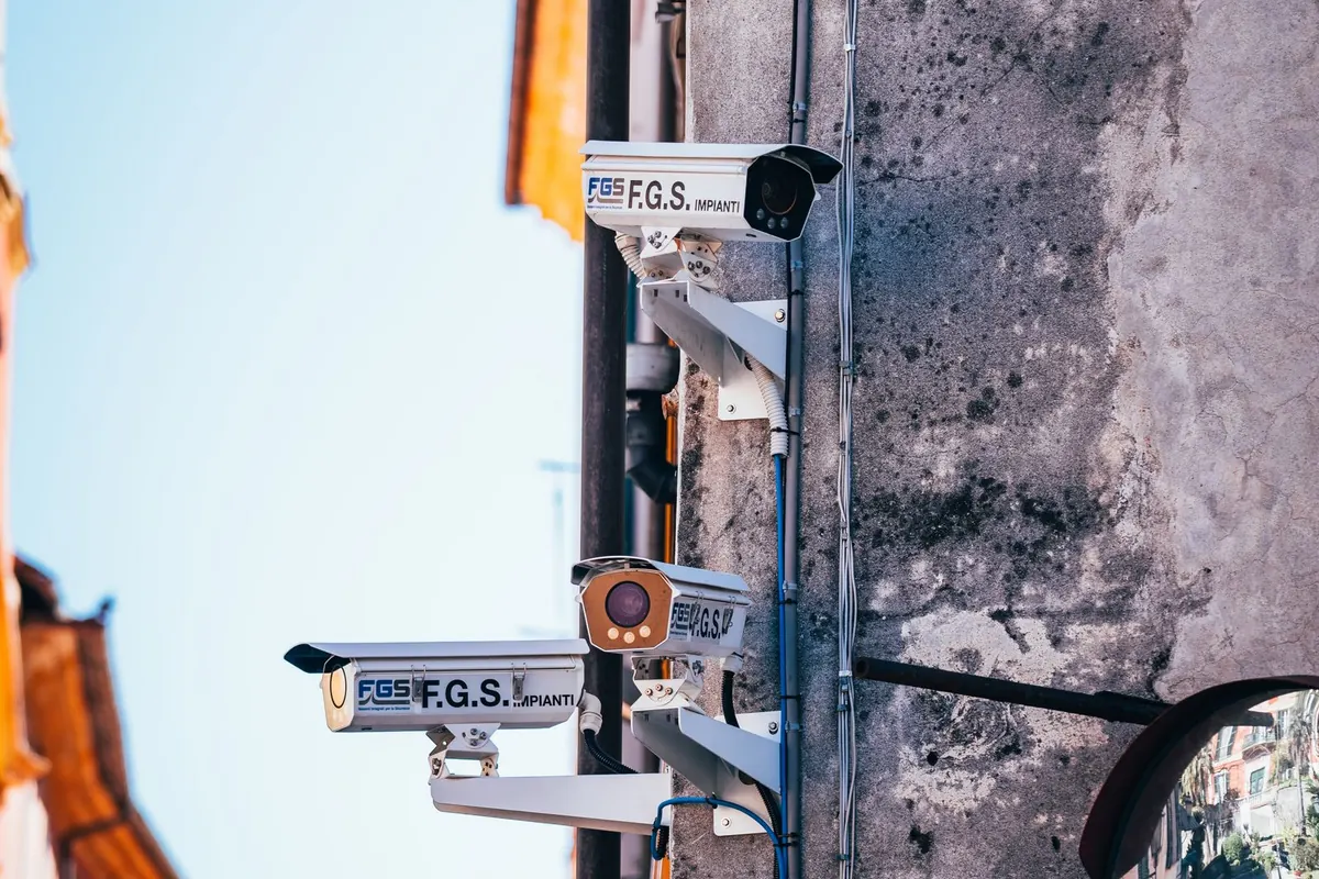 Videosorveglianza a Latina: telecamere di sicurezza installate su staffa a muro all'esterno, con il cielo sullo sfondo
